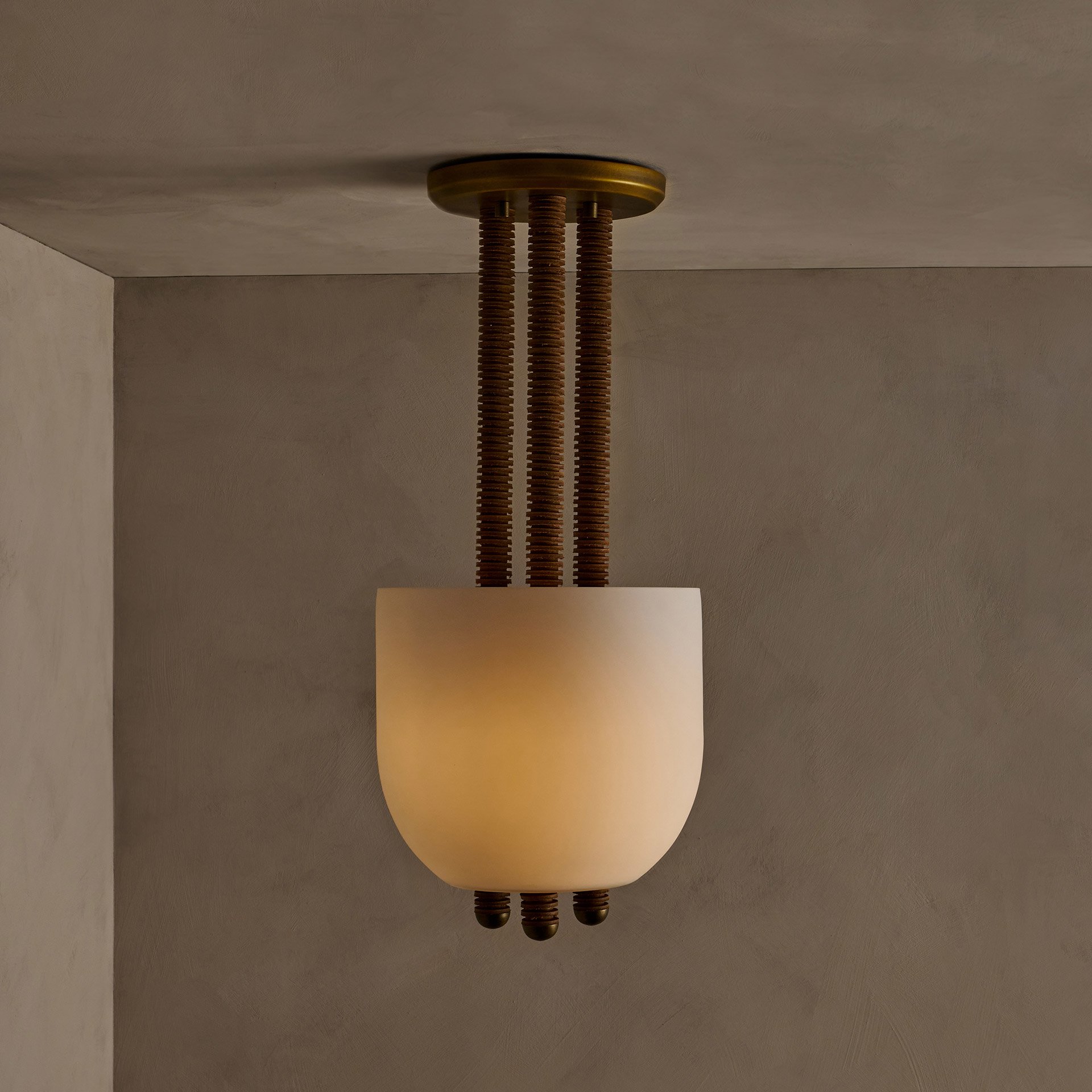 The Folton fixture showcases stacked leather hide disks, celebrating natural imperfections. A frosted glass shade illuminates the leather's edge while supports create a seamless union of components.