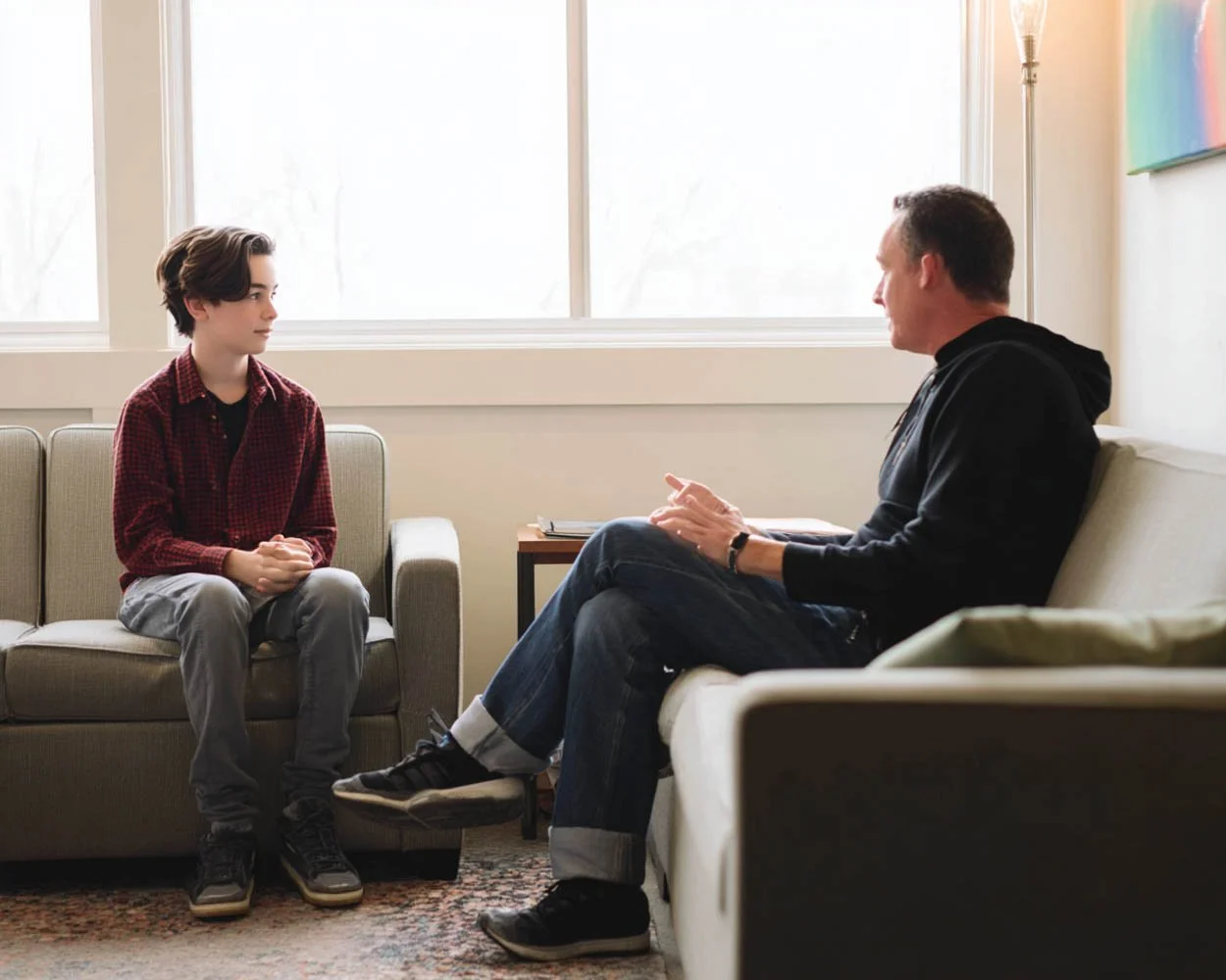 Teen speaking with therapist during adolescent cognitive behavioral therapy session