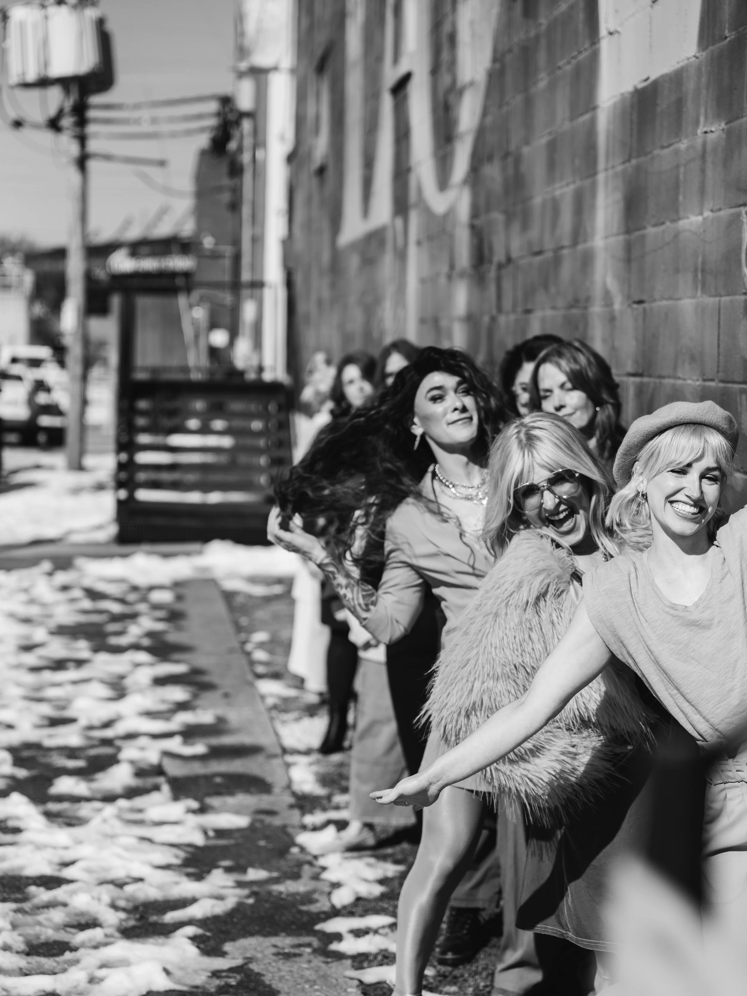 Candid team branding portrait of Louisville hair and makeup artists captured with natural movement and energy.