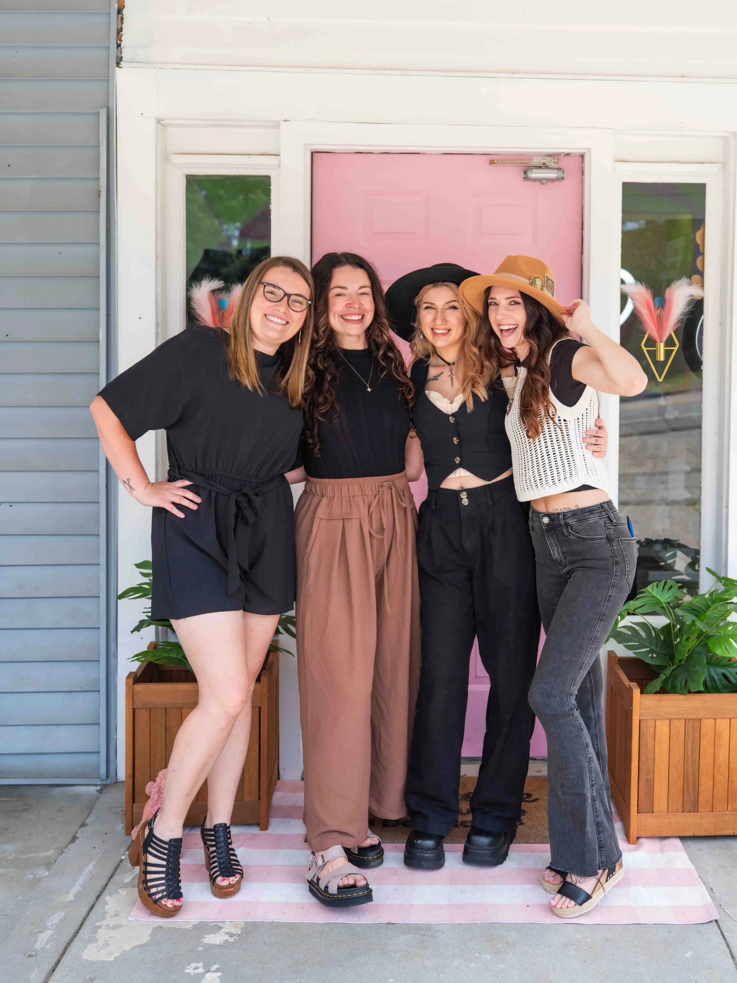 dog groomers in matching outfits in front of a pink door during a personal branding photoshoot