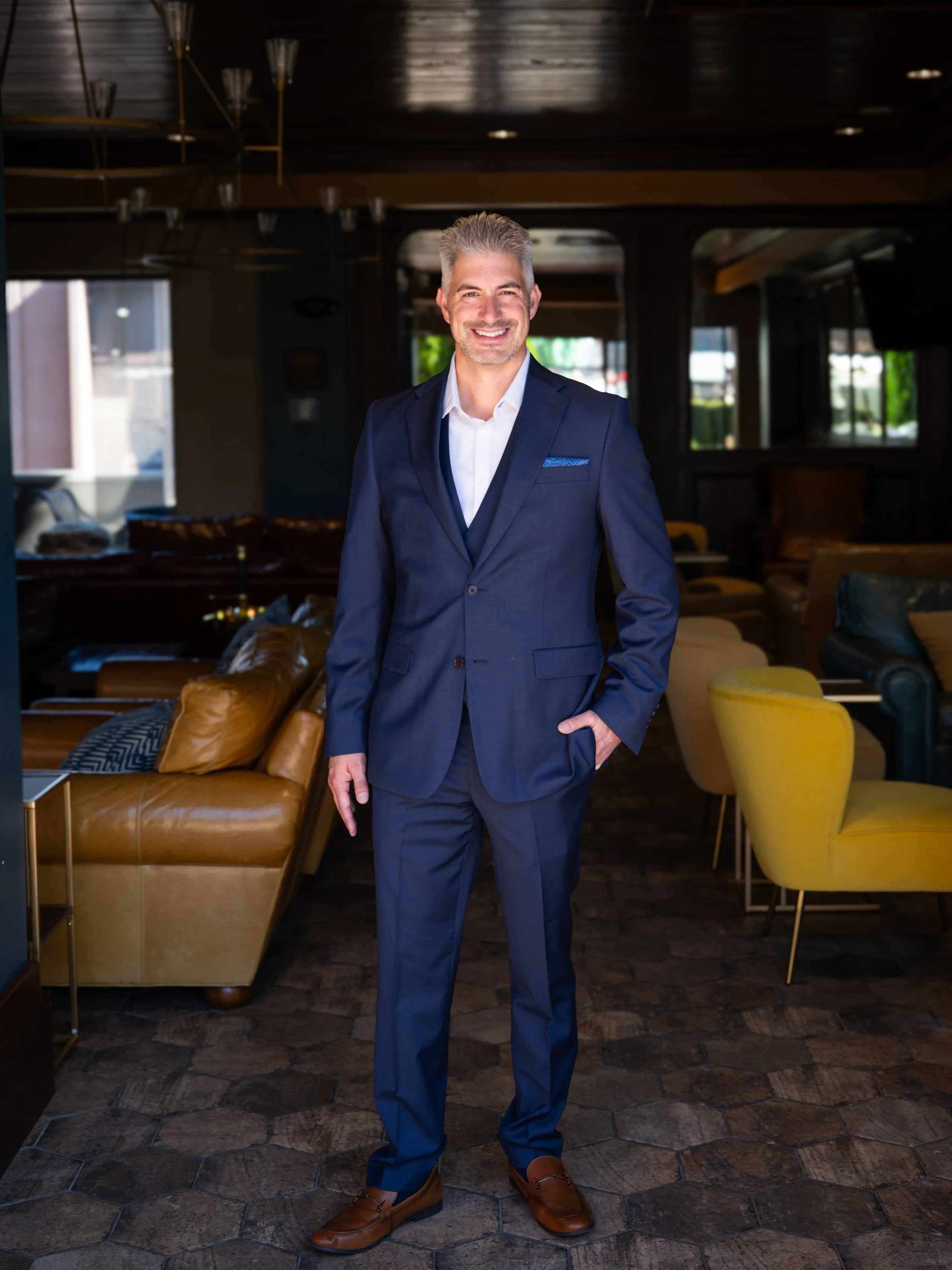 Professional branding photo of man in tailored blue suit at historic Louisville Thoroughbred Club.