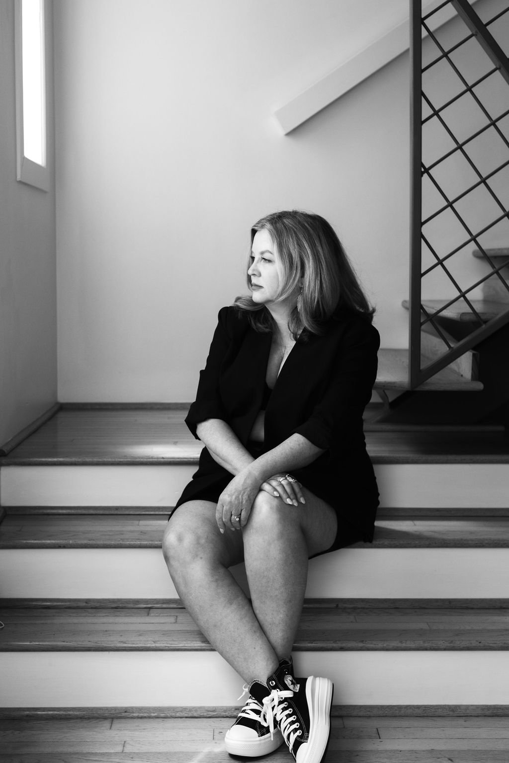 black and white editorial portrait of woman on stairs