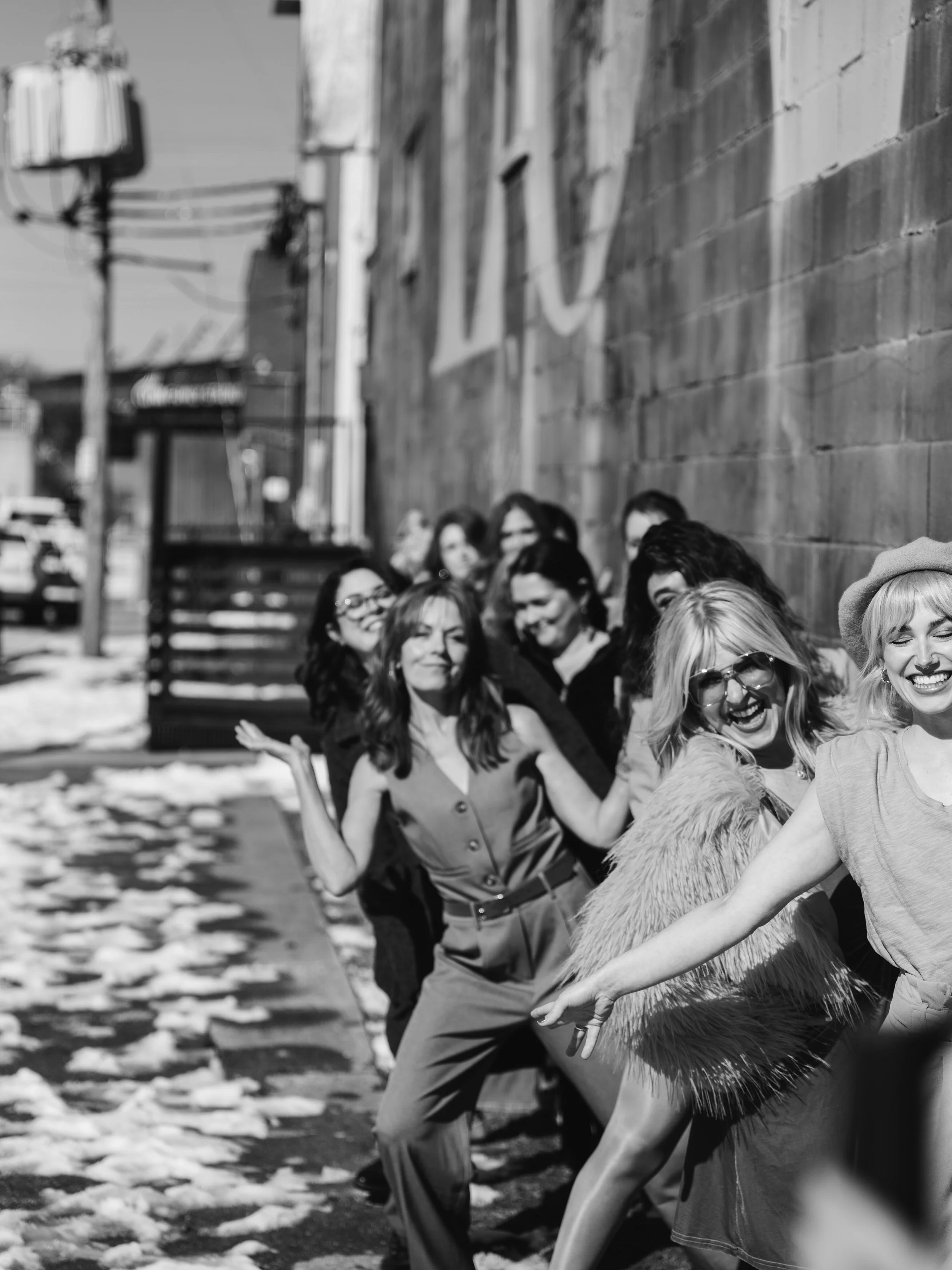 Candid team branding portrait of Louisville hair and makeup artists captured with natural movement and energy.