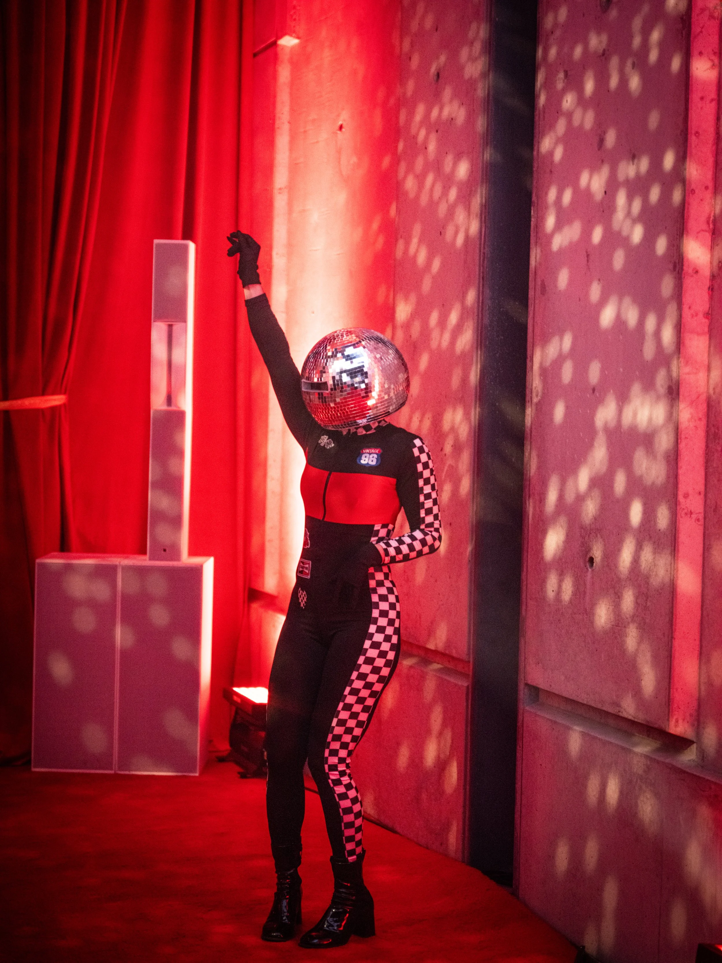 Performer in checkered racing suit with mirror ball at REV Indianapolis 2026 photographed by Jama Finney Indianapolis culinary and event photographer