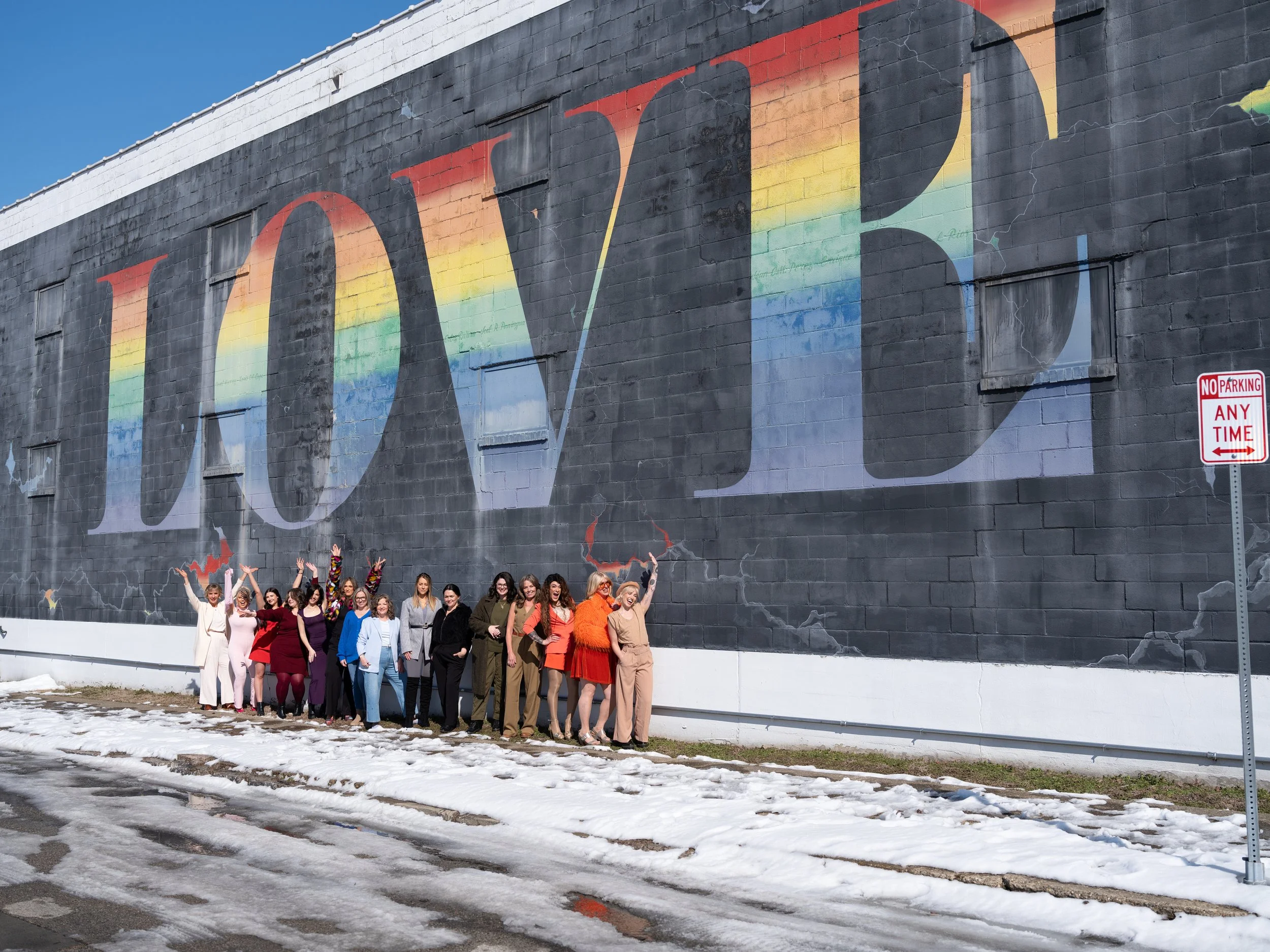 Creative team branding portrait in front of the LOVE mural at PLAY in Louisville, Kentucky.