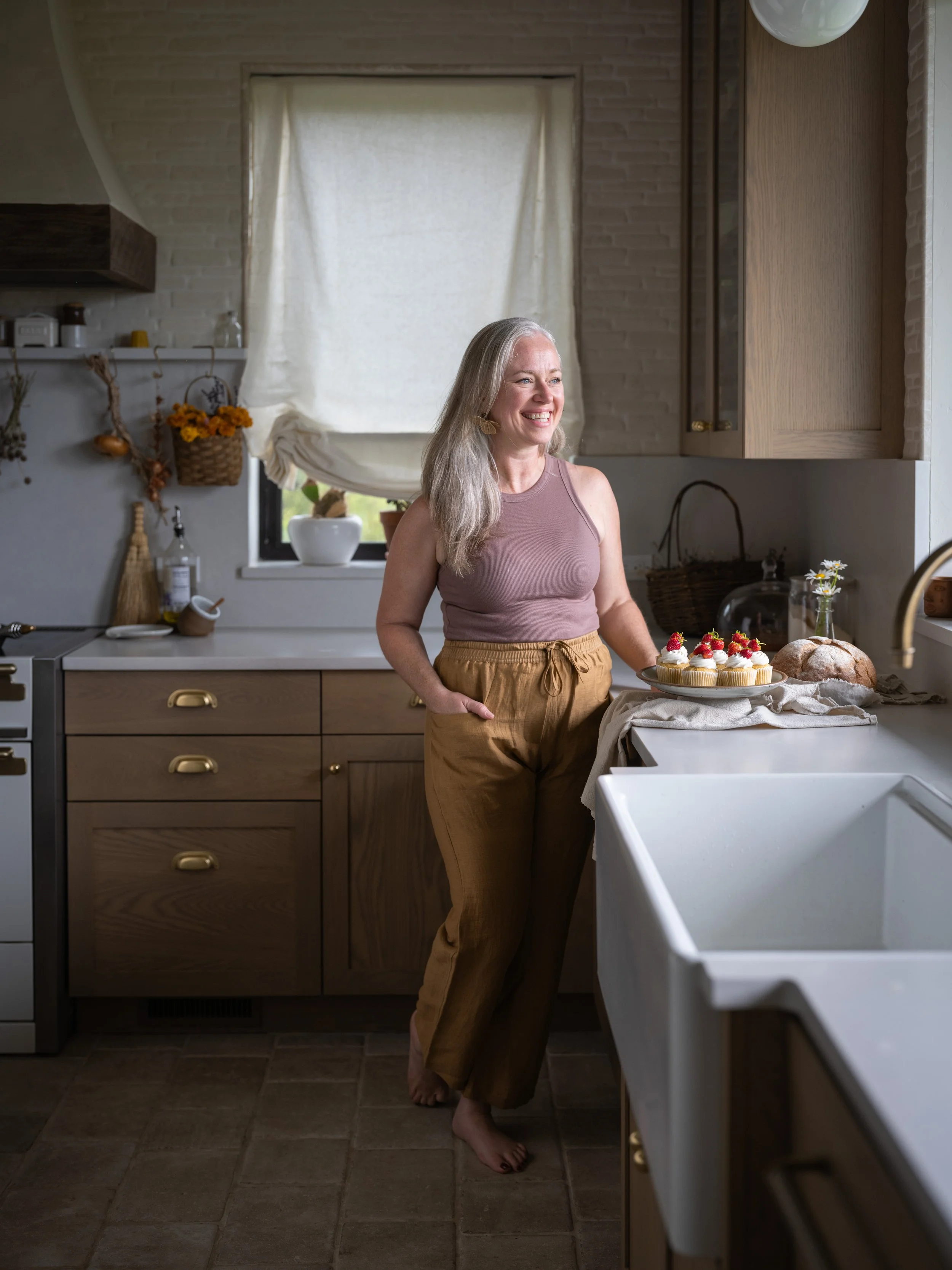 Jama Finney with a plate of strawberry cupcakes in Eva Kosmas Flores's kitchen