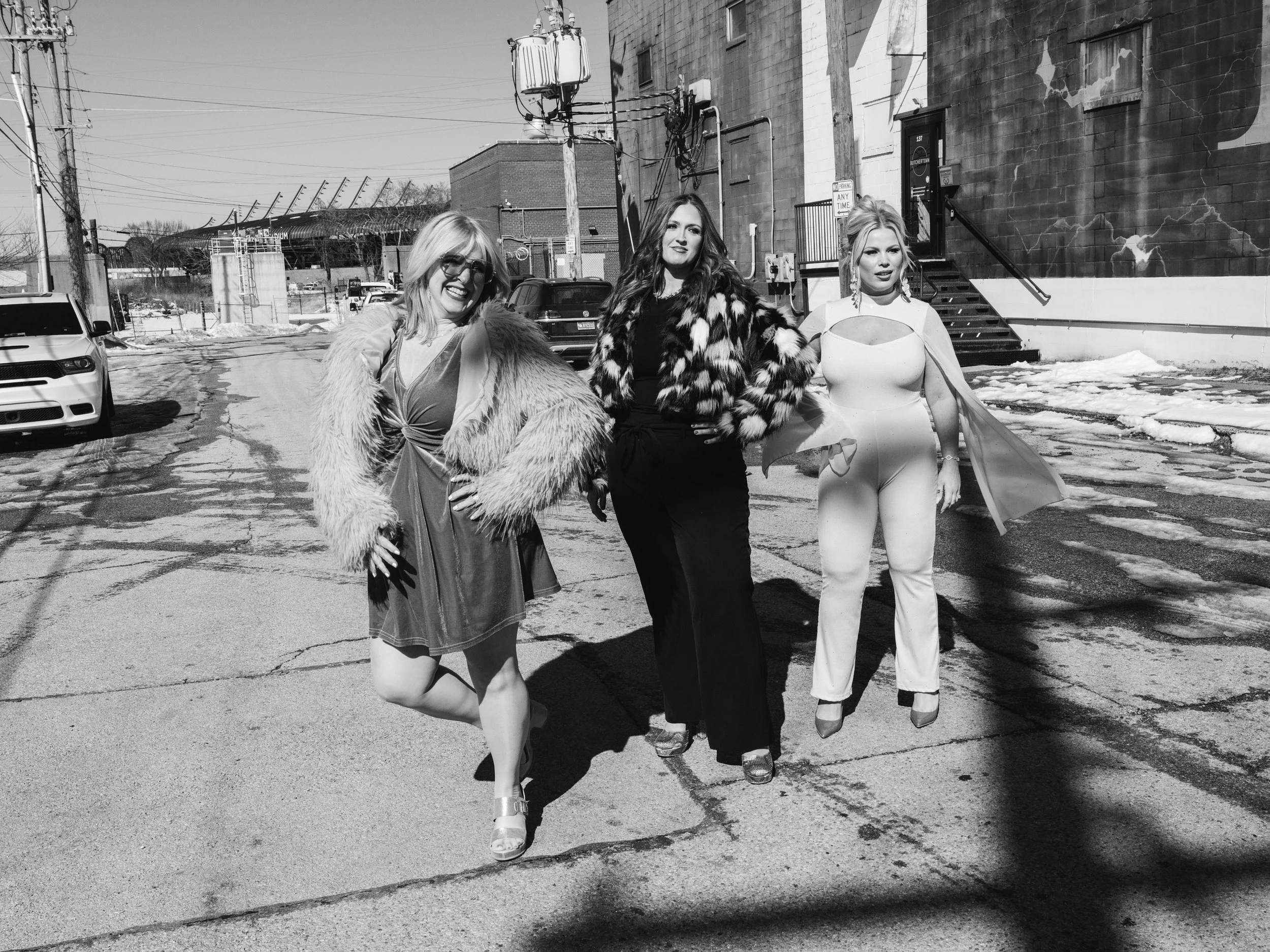 Candid team branding portrait of Louisville hair and makeup artists captured with natural movement and energy.