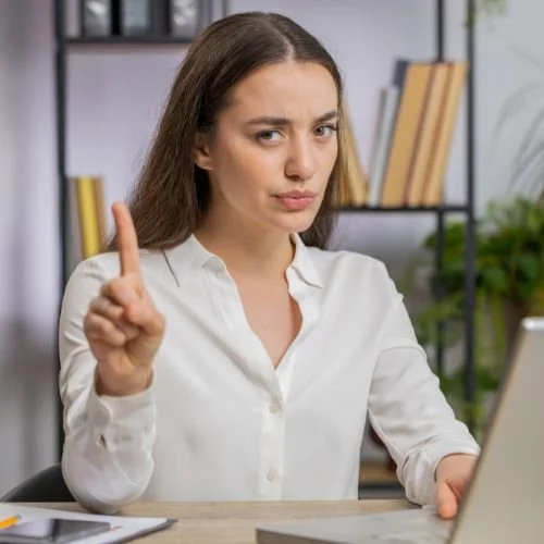 A person holding one finger up as if to say, "Wait."