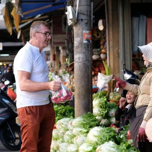 A man buying vegetables at a farmer's market.