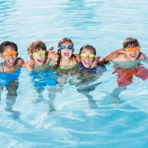 Kids swimming in a pool.