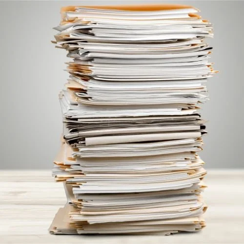 A tall pile of papers and folders.