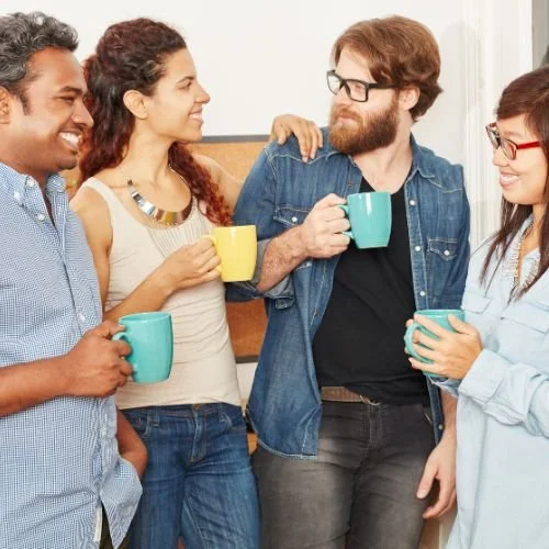 People drinking coffee in a break room.