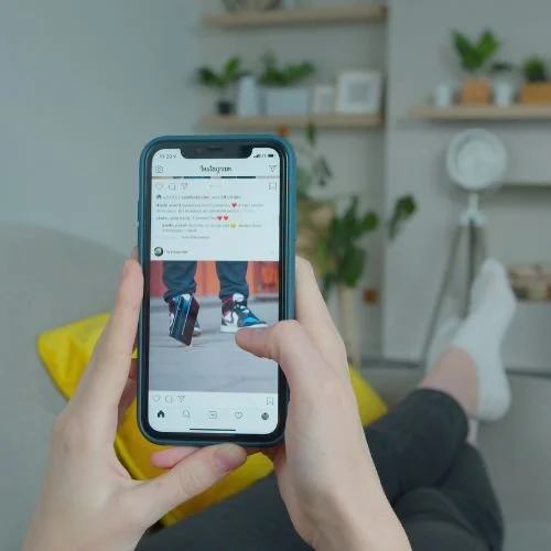 Someone scrolling Instagram on a smartphone.
