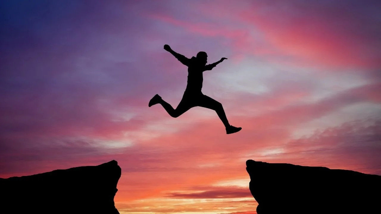 A person jumping across a chasm.