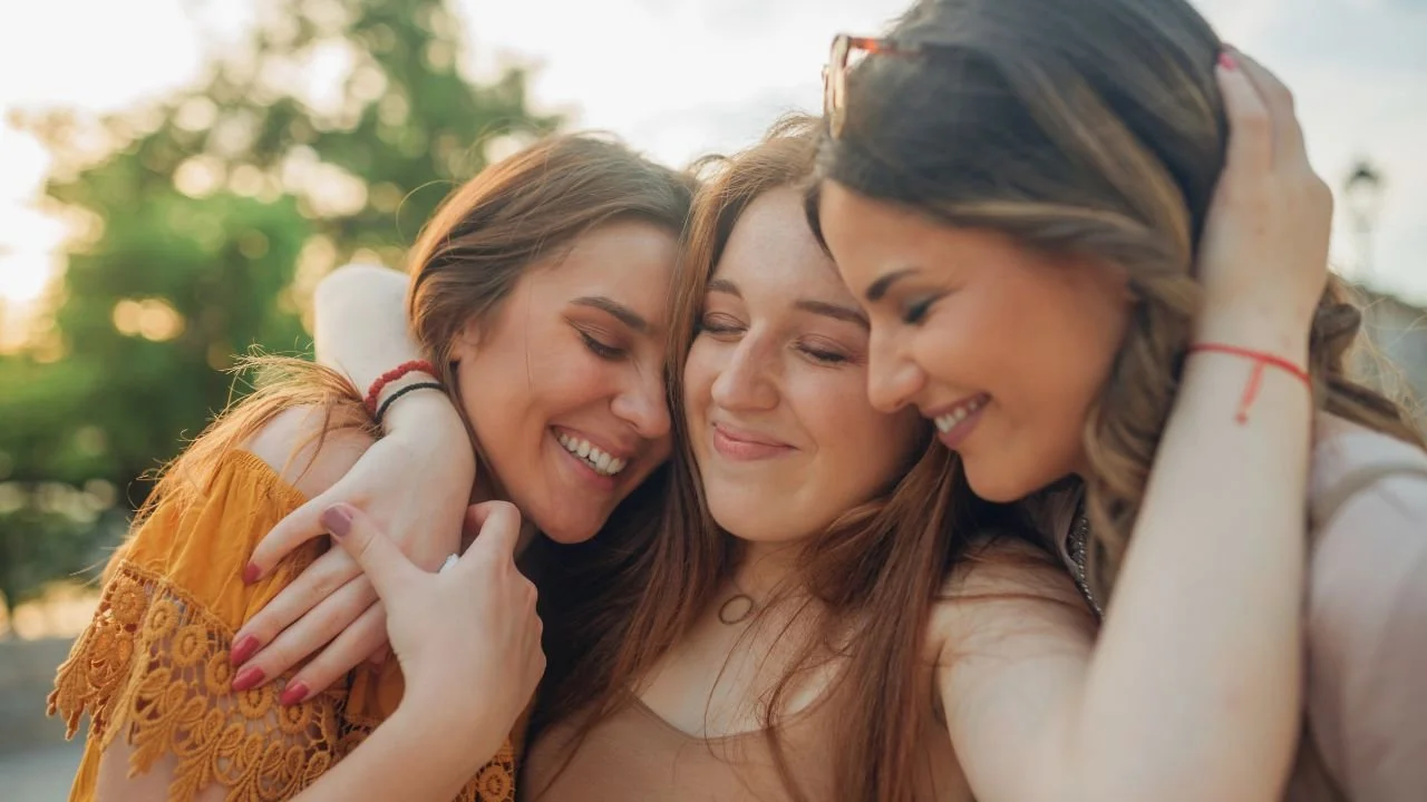 Three women hugging.