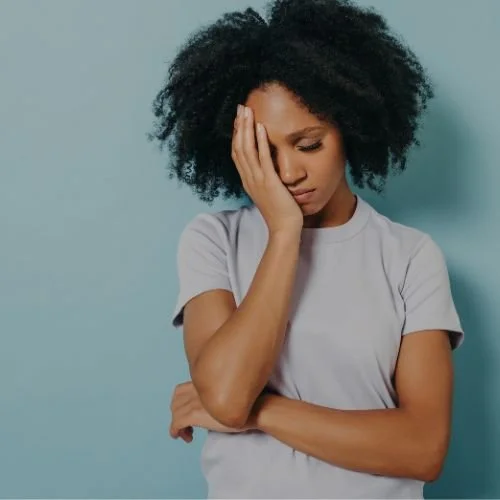 A woman holding her head in her hands.