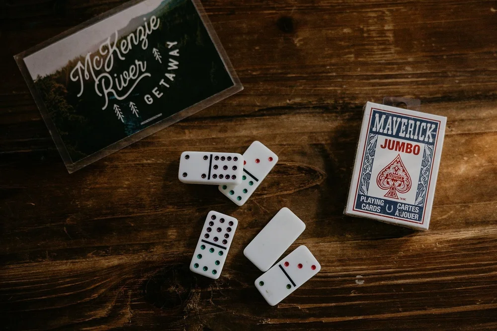 McKenzie River Getaway playing cards and dominoes on a wood table