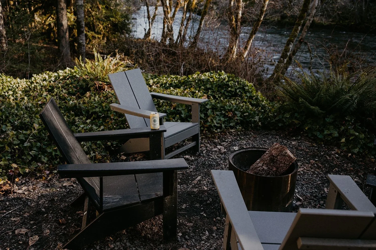 Adirondack chairs around the fire pit above the rushing McKenzie River