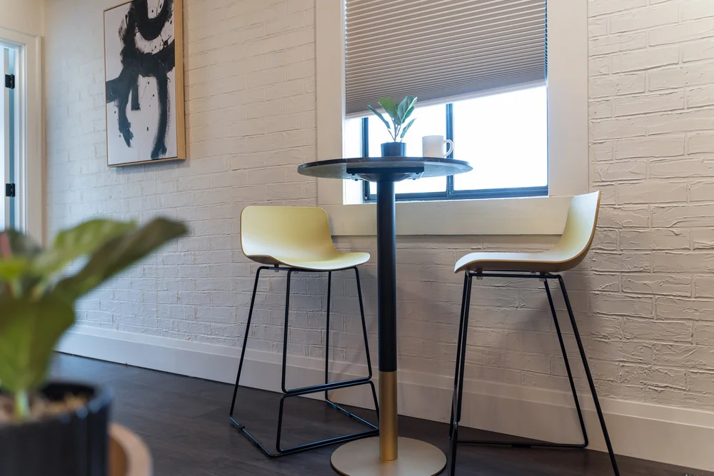 A bistro table by the window in the Storyteller suite