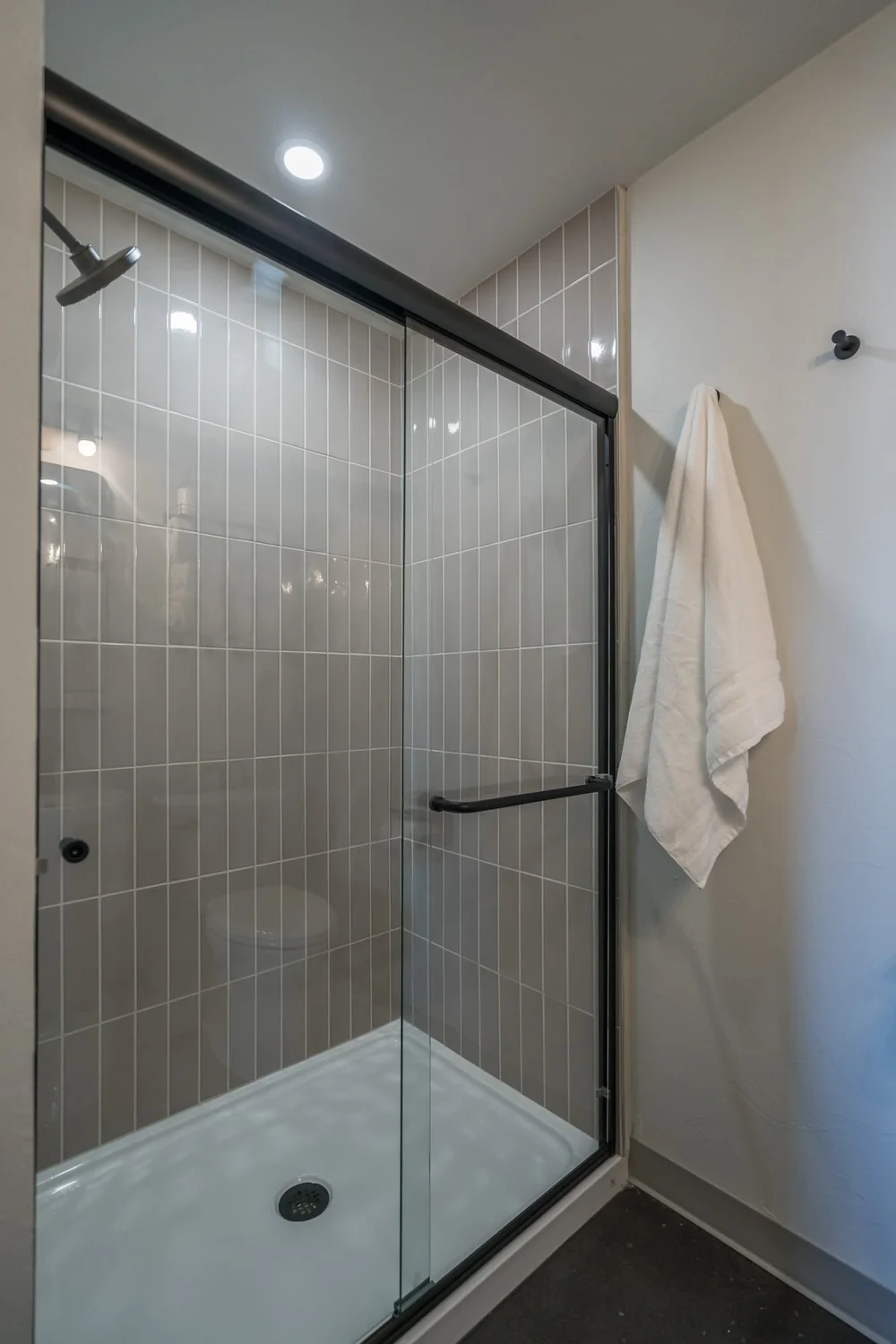 A tiled step-in shower with a glass door