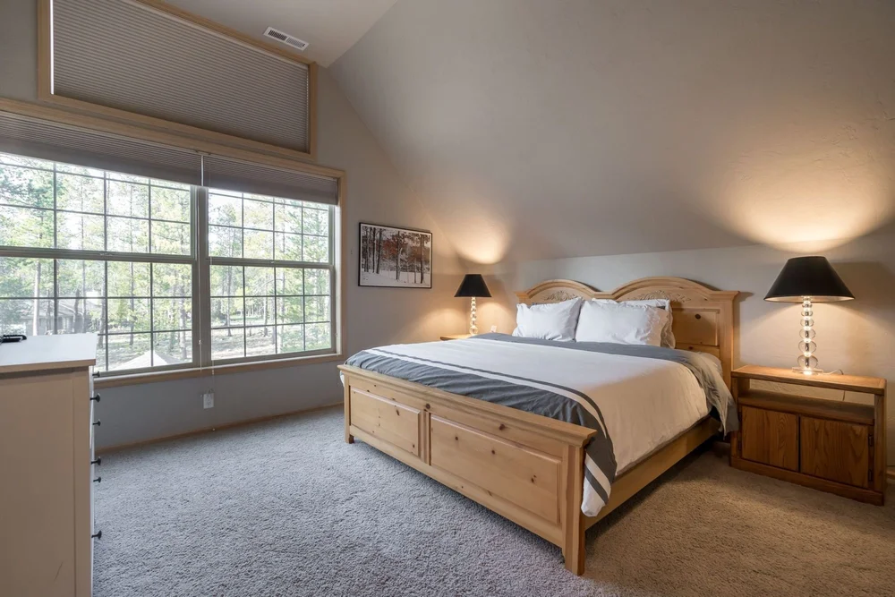 Primary bedroom with a king bed and windows onto the pines
