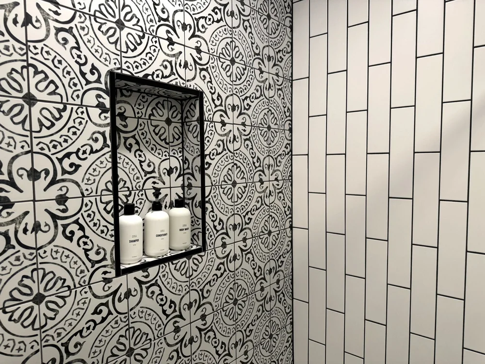 Walk-in shower with black and white patterned tile