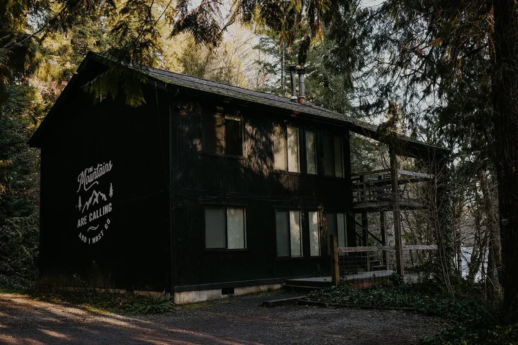 The black McKenzie River cabin among the trees