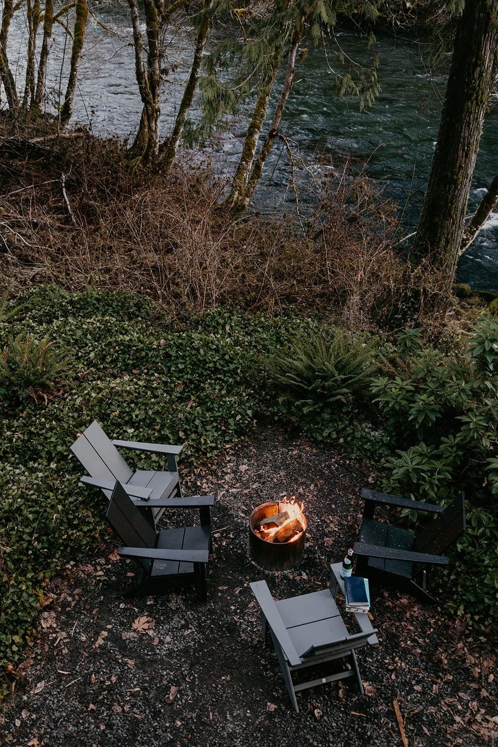Adirondack chairs around the Solo Stove fire pit by the river