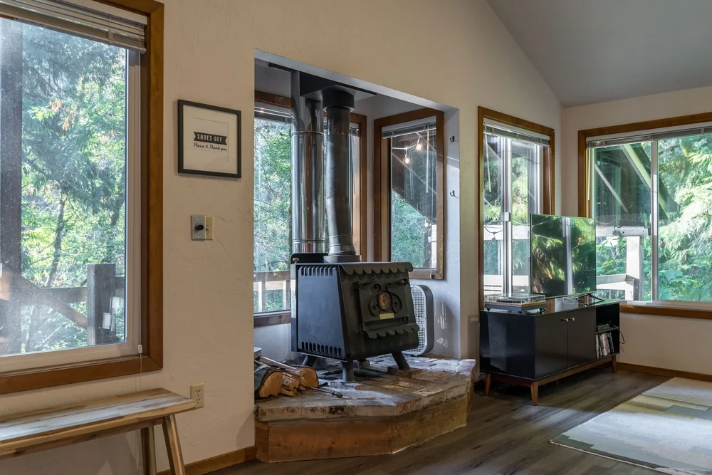 Woodstove on a raised hearth by the windows