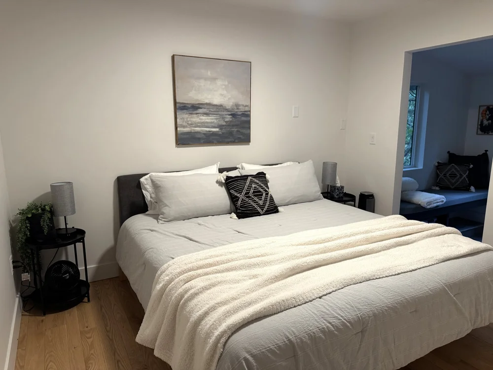 King bed on the upper floor with coastal art above it