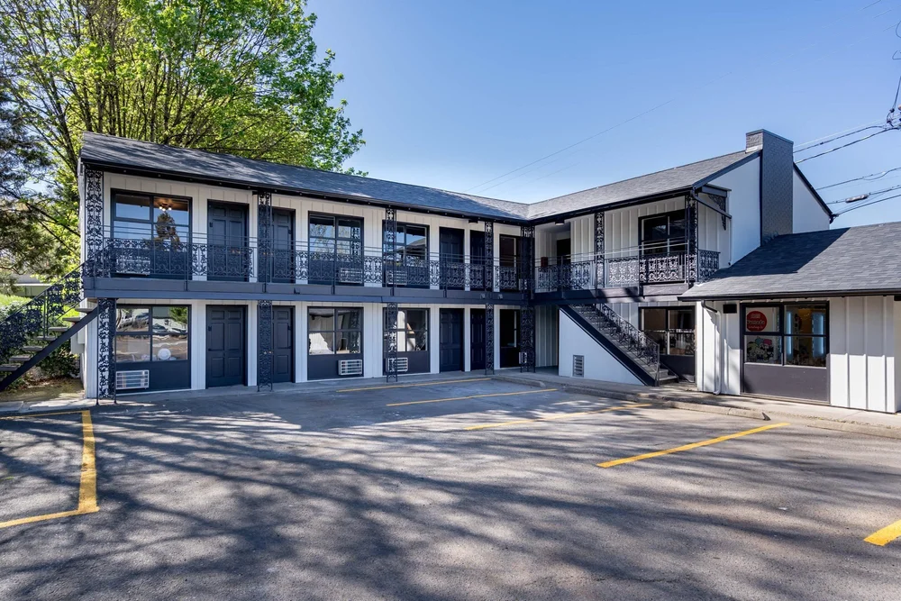 The shared parking lot and two floors of rooms at The Local