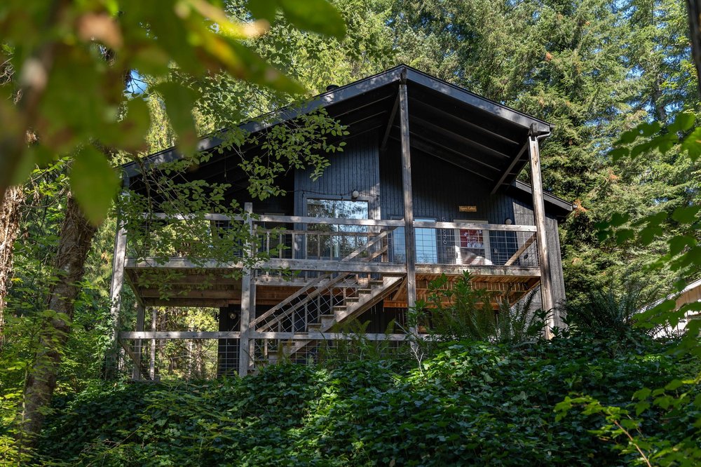 The cabin and its two-level deck among the trees