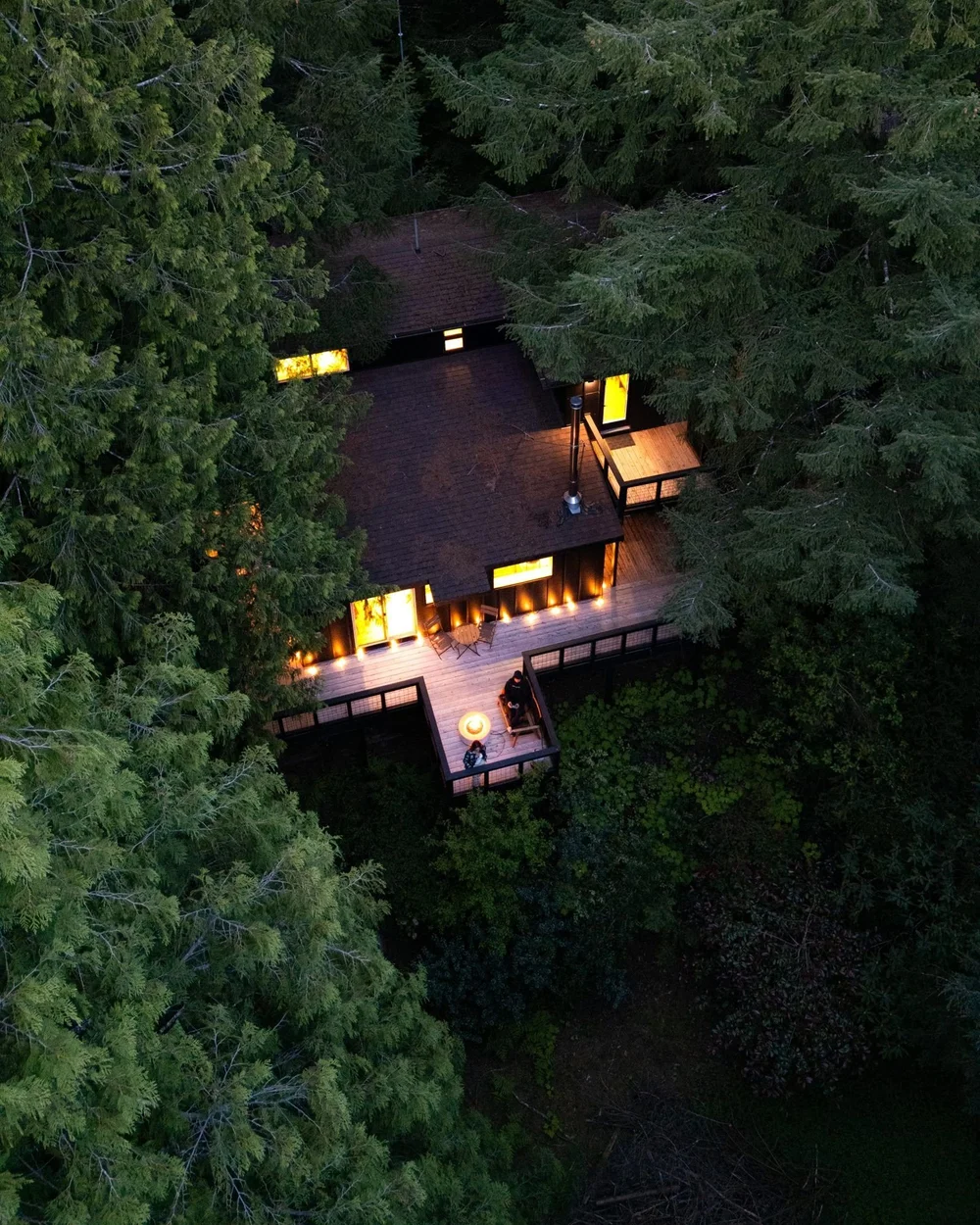 Aerial view of the lake house at night in the forest