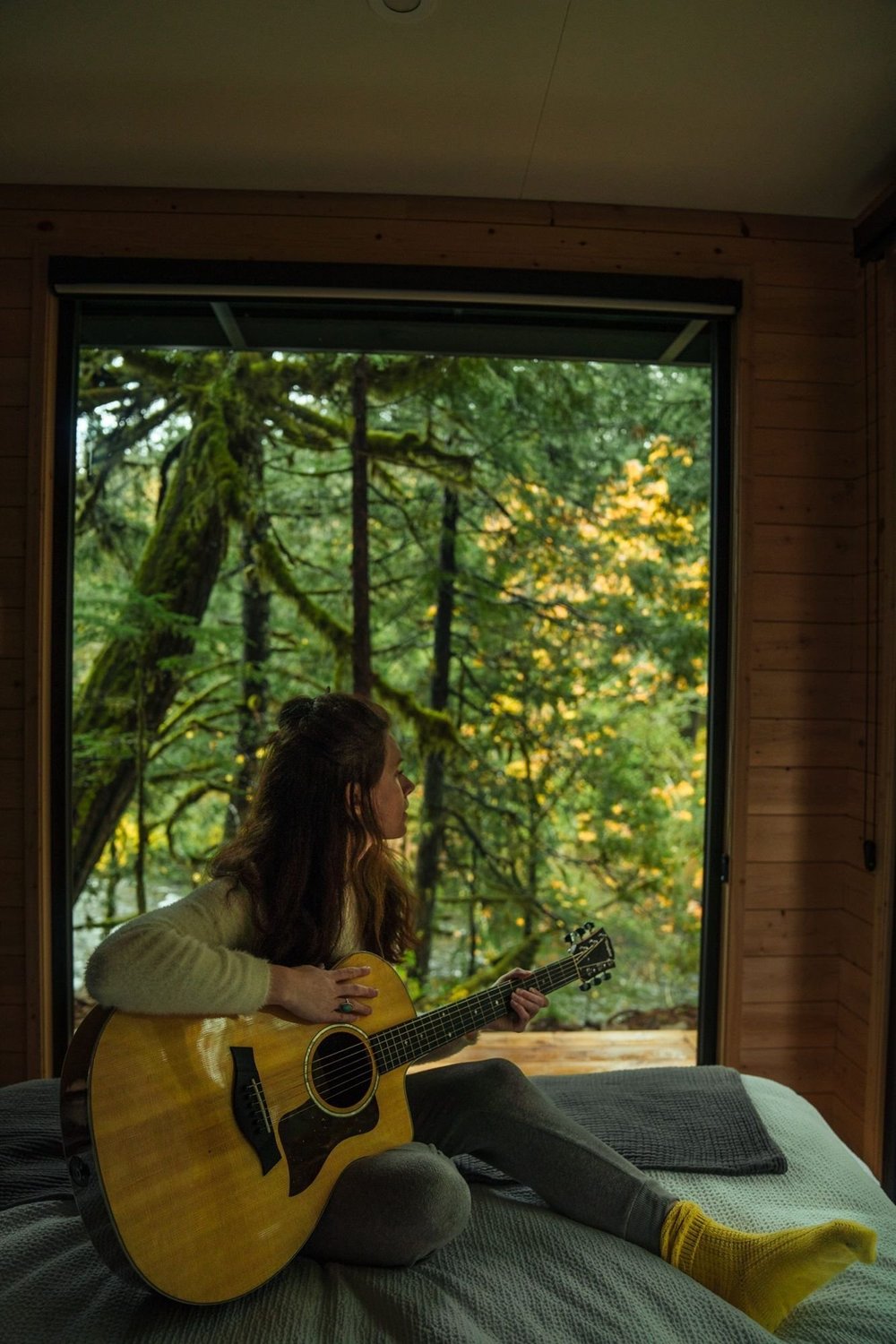 A guest playing guitar in the bedroom picture window