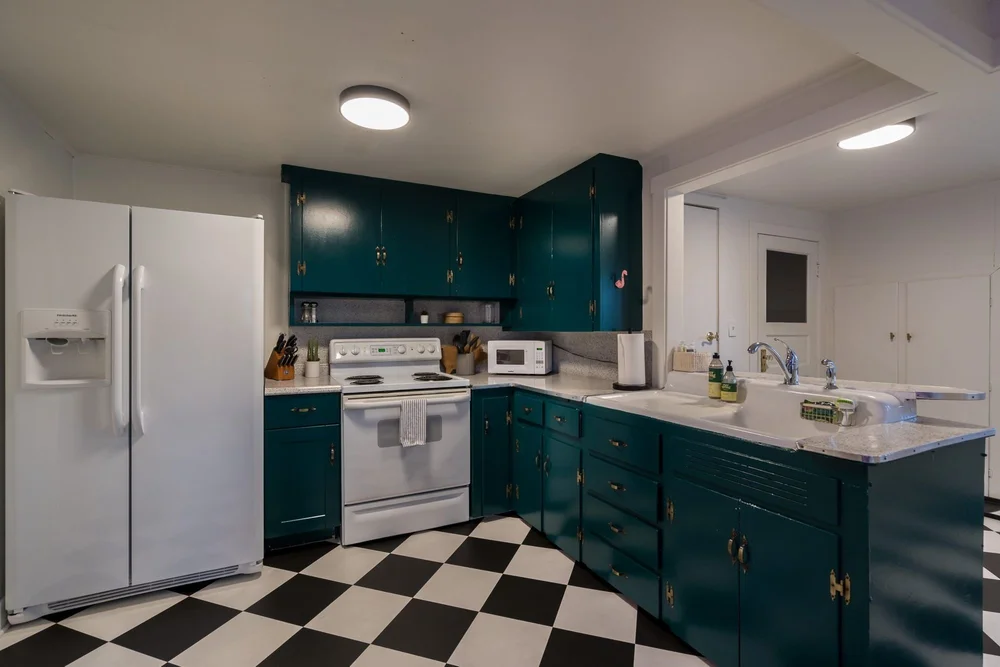 Teal kitchen with a black and white checkered floor