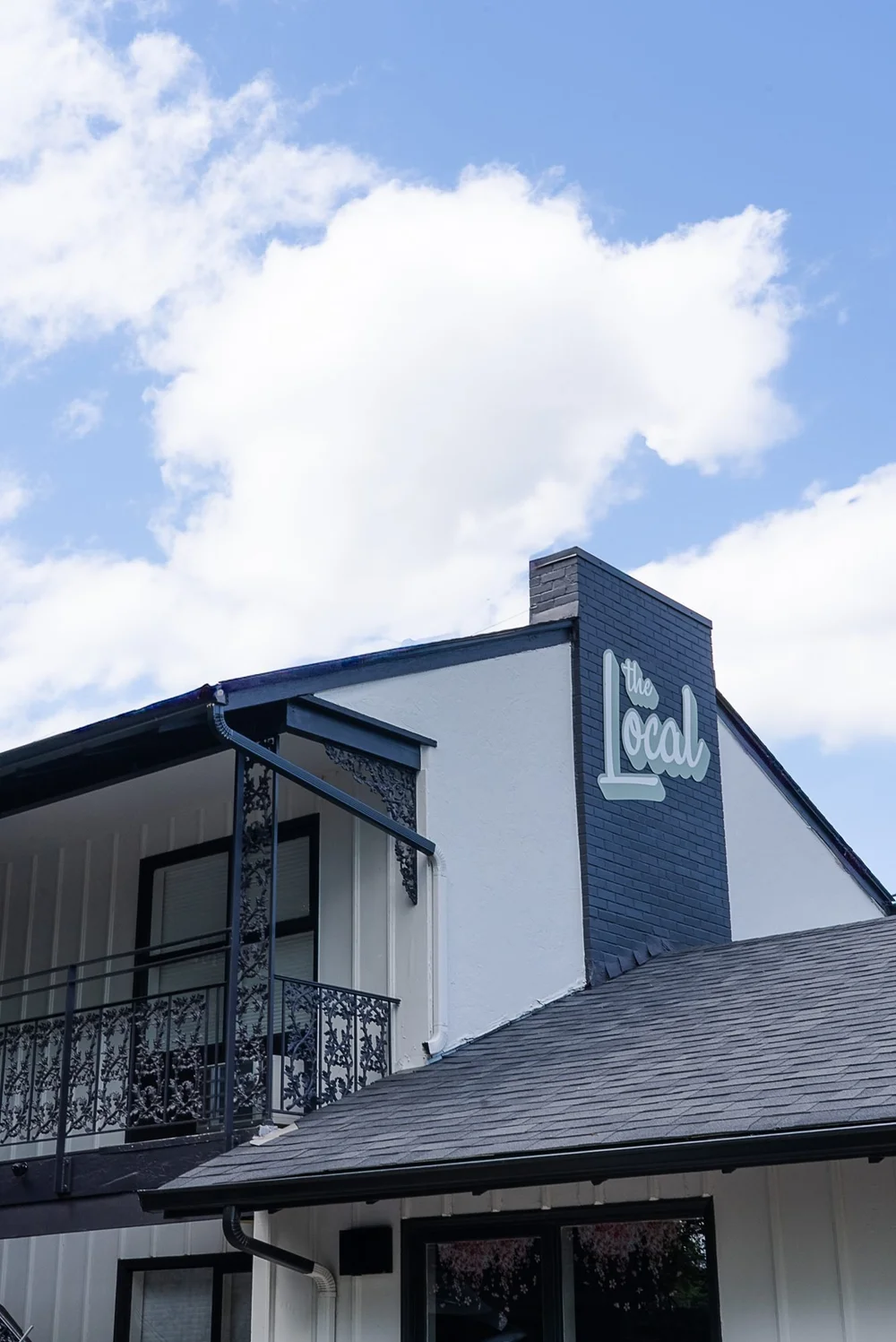 The Local building and sign against a blue sky