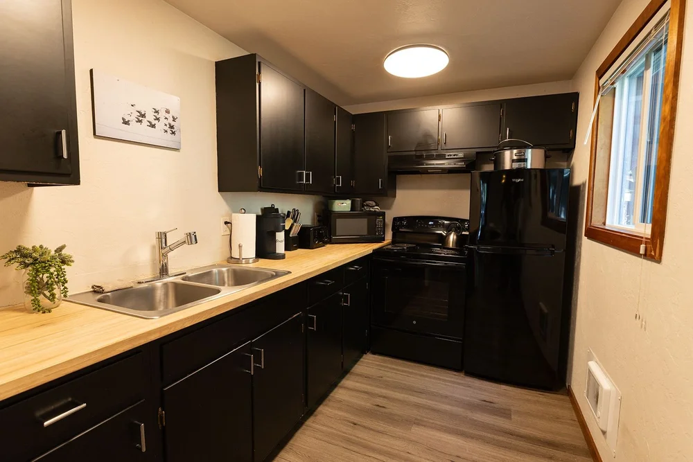 Kitchen with black cabinets and butcher block counters