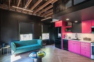 The Rockstars Loft, with a pink kitchen, teal sofa and exposed beams