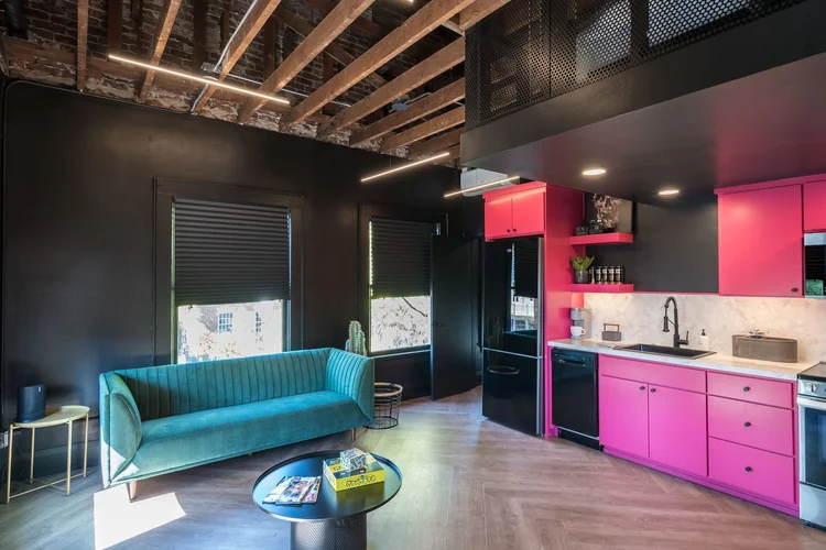 The Rockstars Loft, with a pink kitchen, teal sofa and exposed beams