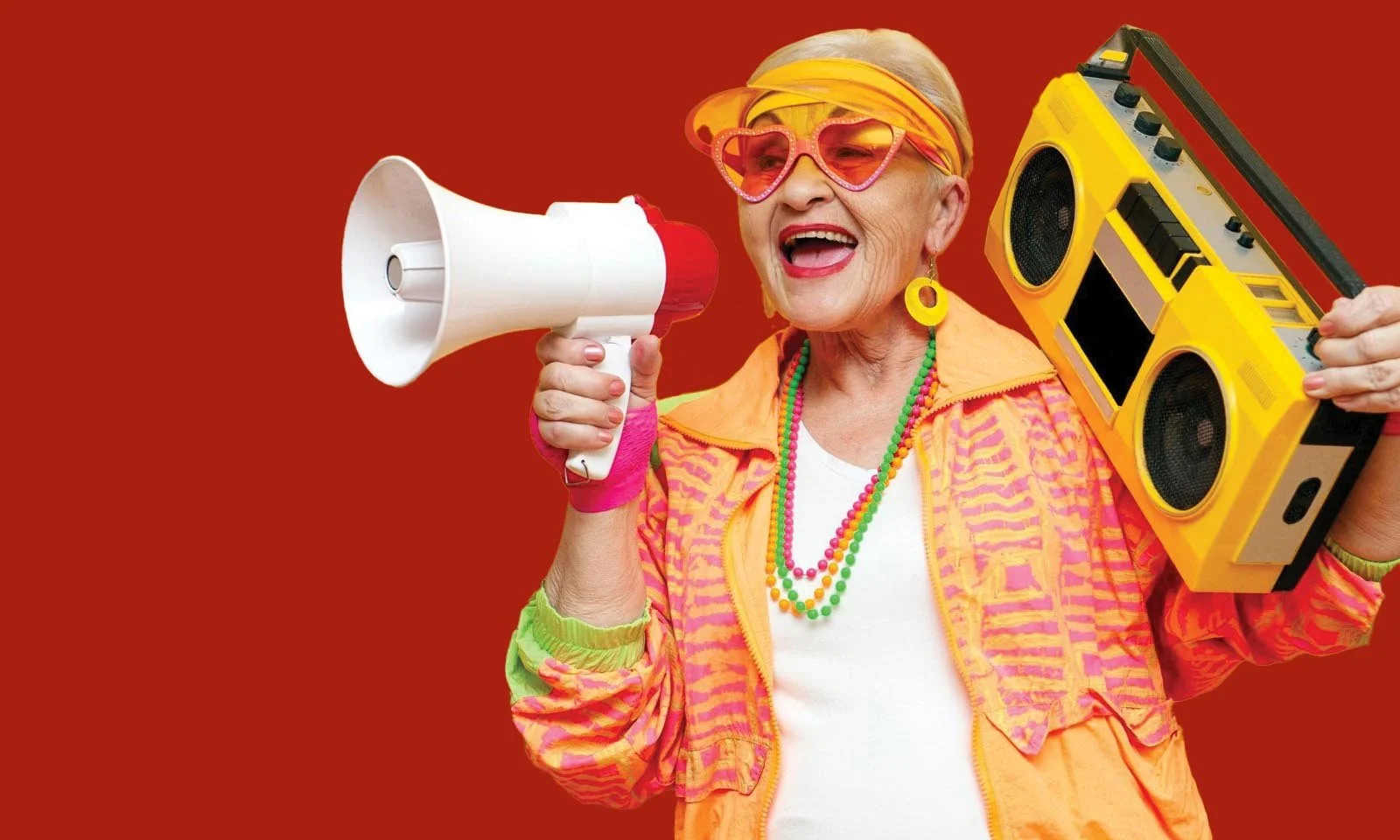 Older woman with a ghetto blaster and a bull horn on a bright Red background