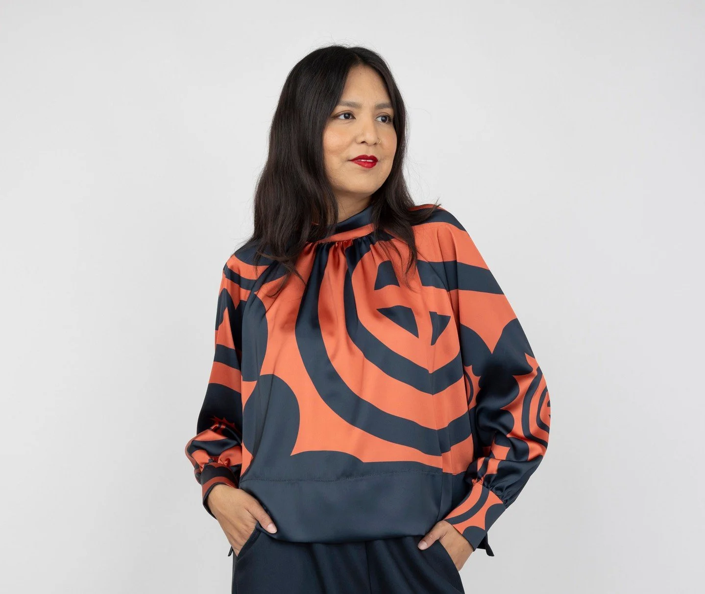 Meet the Winter Copper Blouse ❄️☀️⁠
⁠
Features a large-scale Sun Circle print in copper and black, plus a loose band collar and raglan sleeves. Extra details include a high-low hem side slits and back button closure 💫⁠
⁠
The entire Winter Copper col