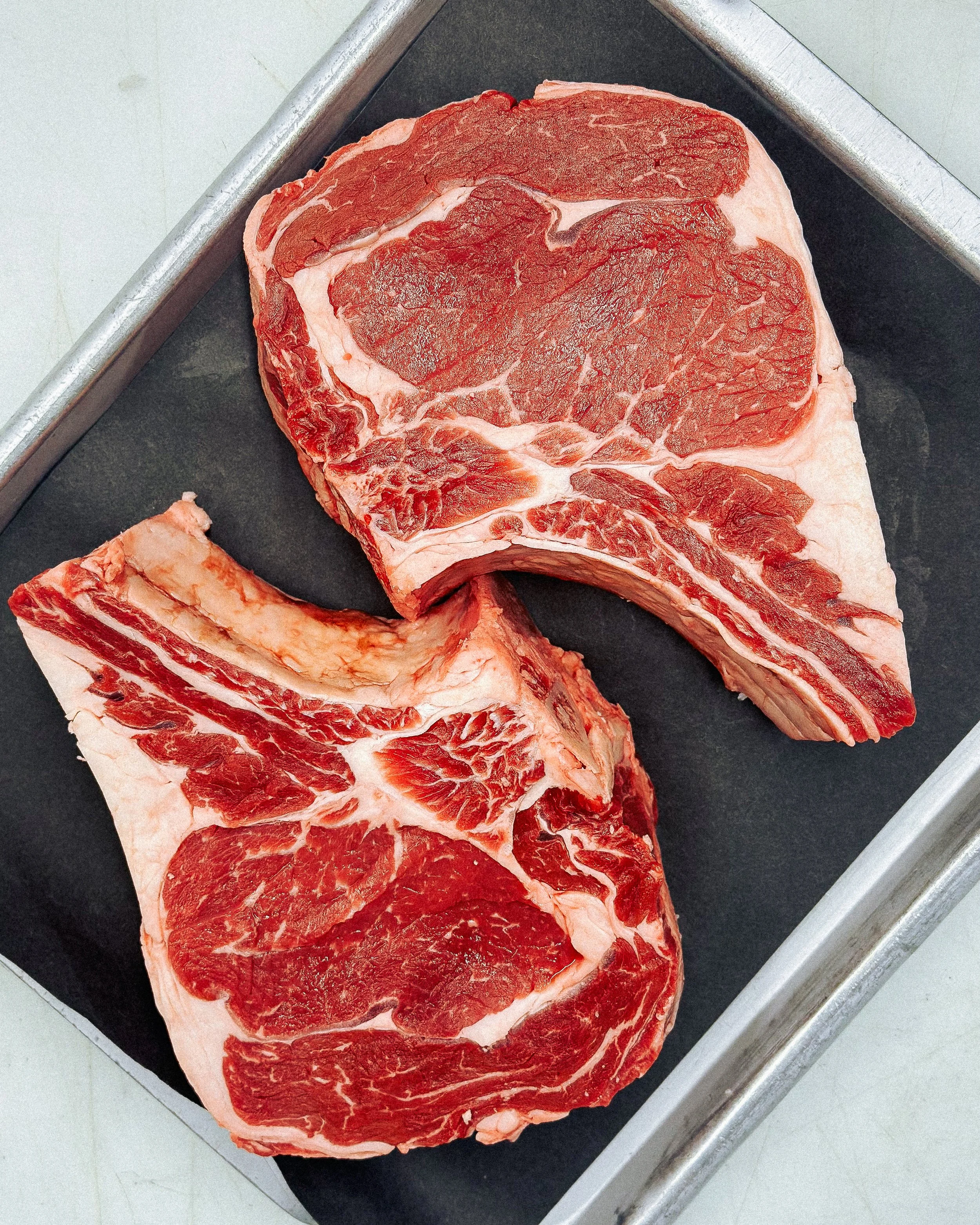 Raw beef steaks on a black cutting board