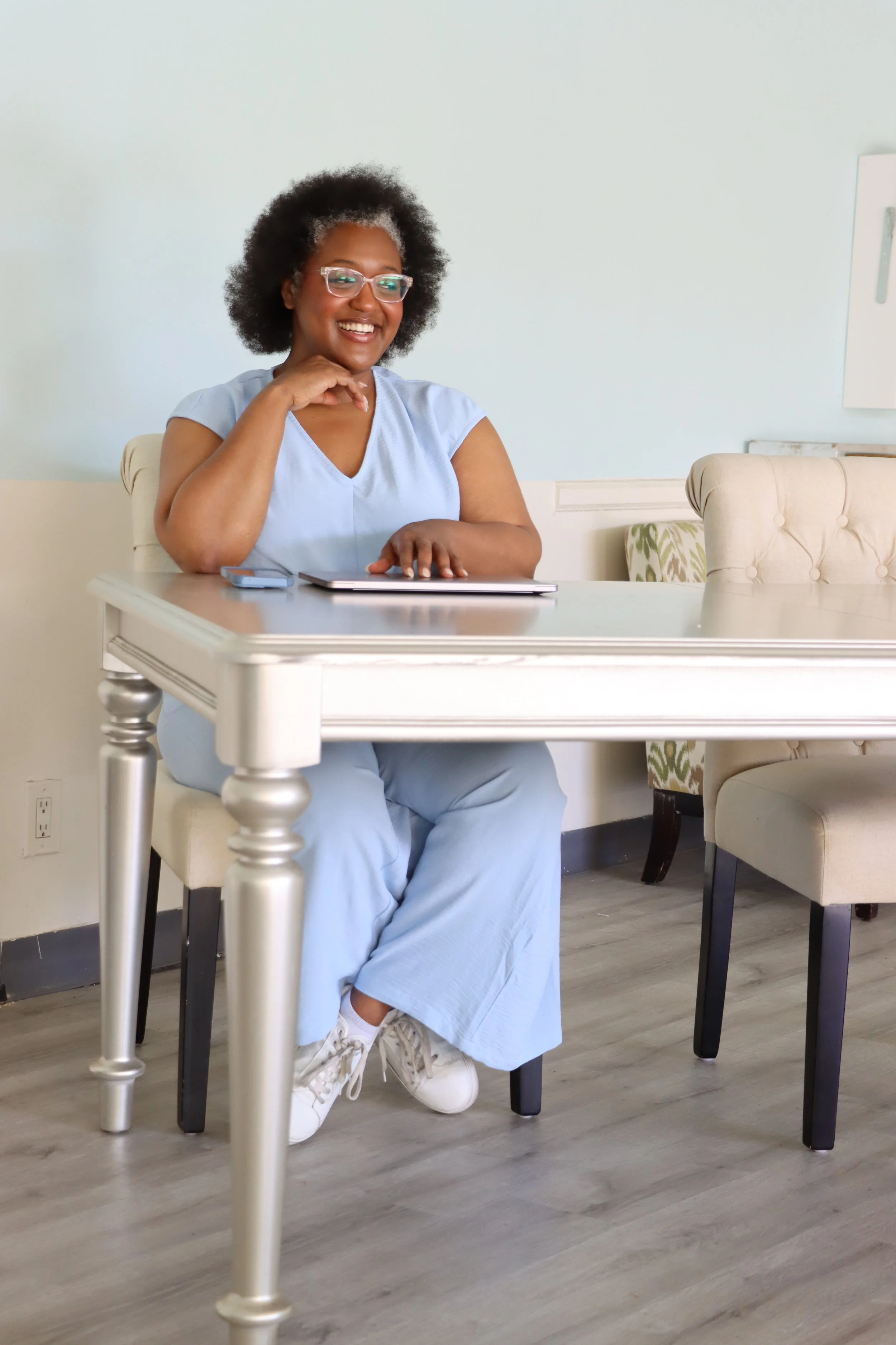 Jenae Thompson, a Fractional CMO, smiling while working at a desk during a strategic marketing audit session.