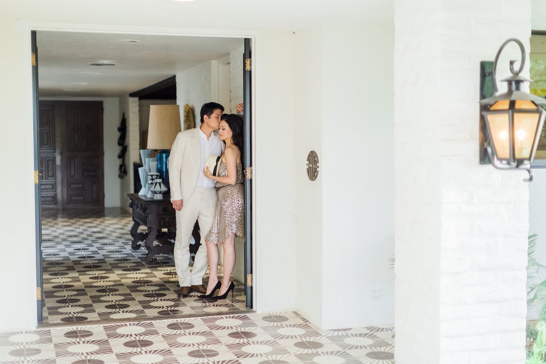Natalie's husband kissing her forehead in a tiled entryway at the Palm Springs property.
