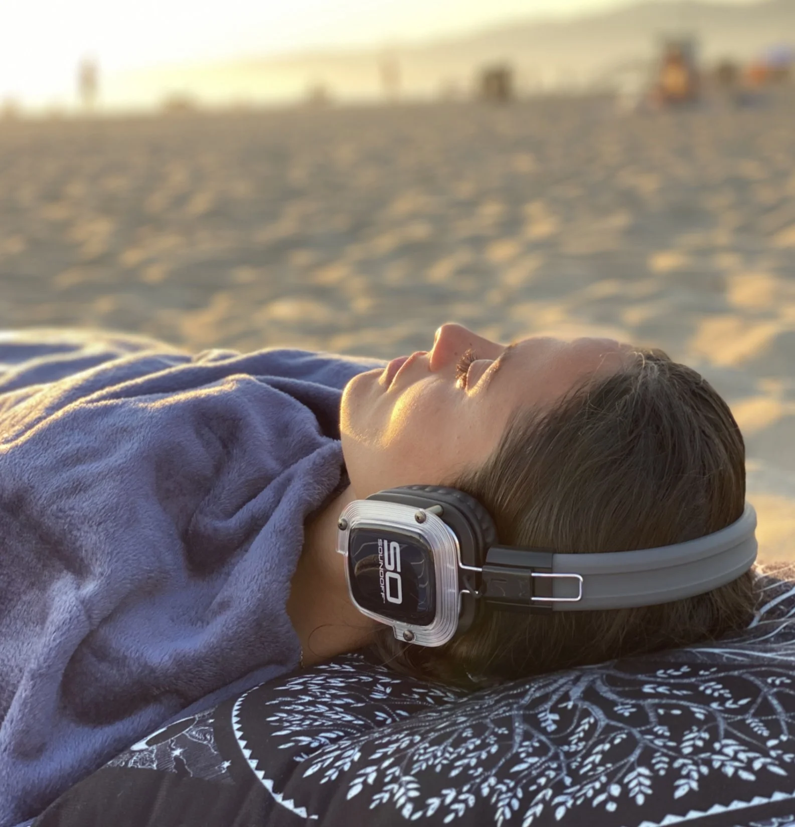 Sound bath meditation on Santa Monica beach, wearing headphones, during sunset.