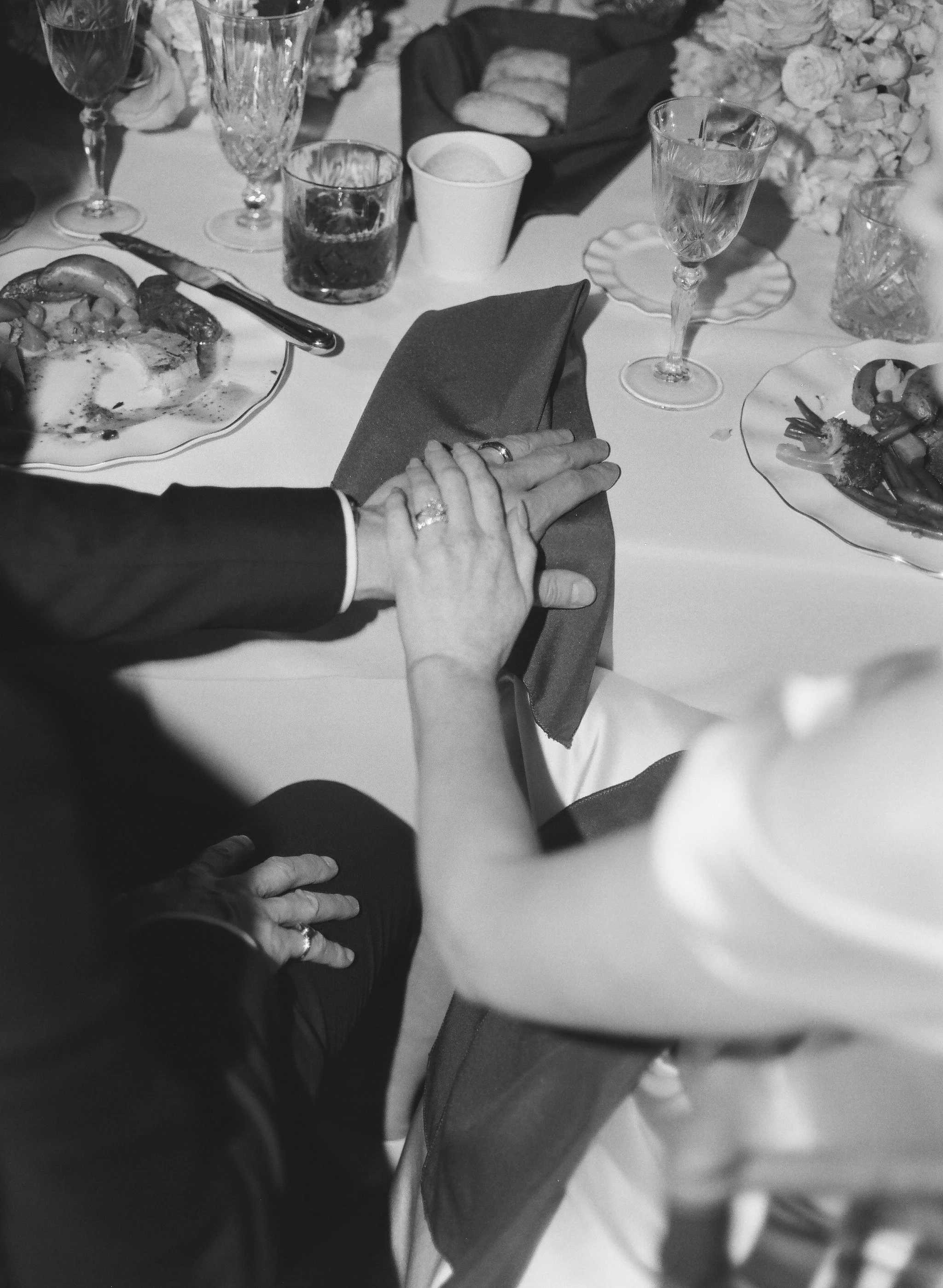 bride and groom resting hands on table full of cocktails and food in kingston new york