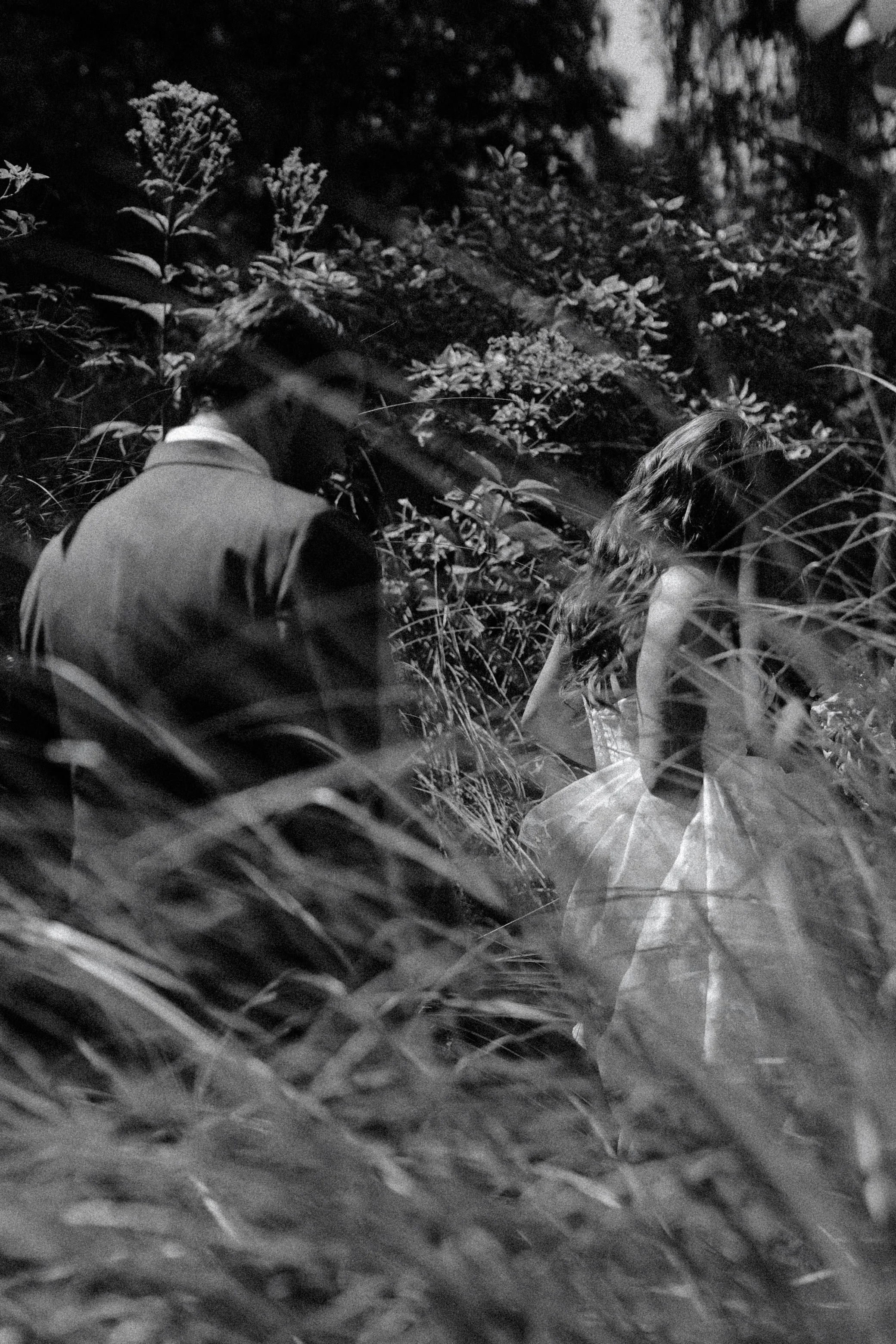 wedding couple walk through tall grass at Buttermilk Falls in and Spa