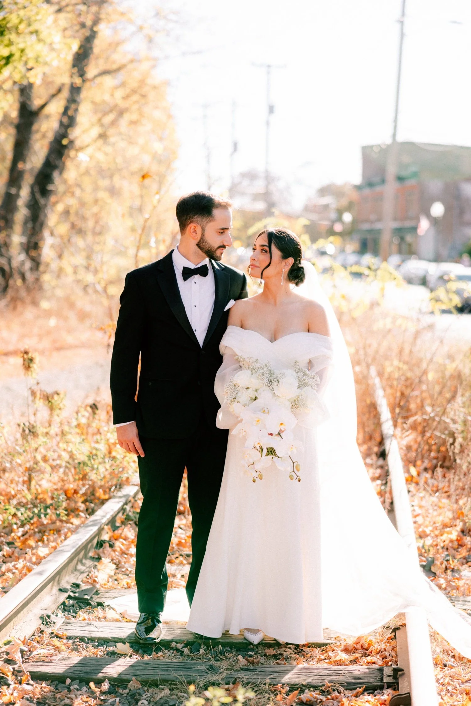 couple looking at each other on the railroad tracks of beacon, ny on their wedding day at the roundhouse