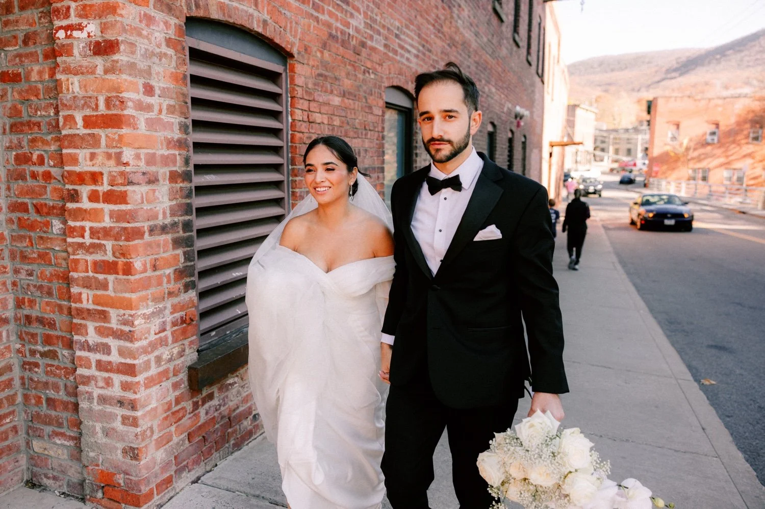 documentary photograph of wedding couple walking in front of the roundhouse