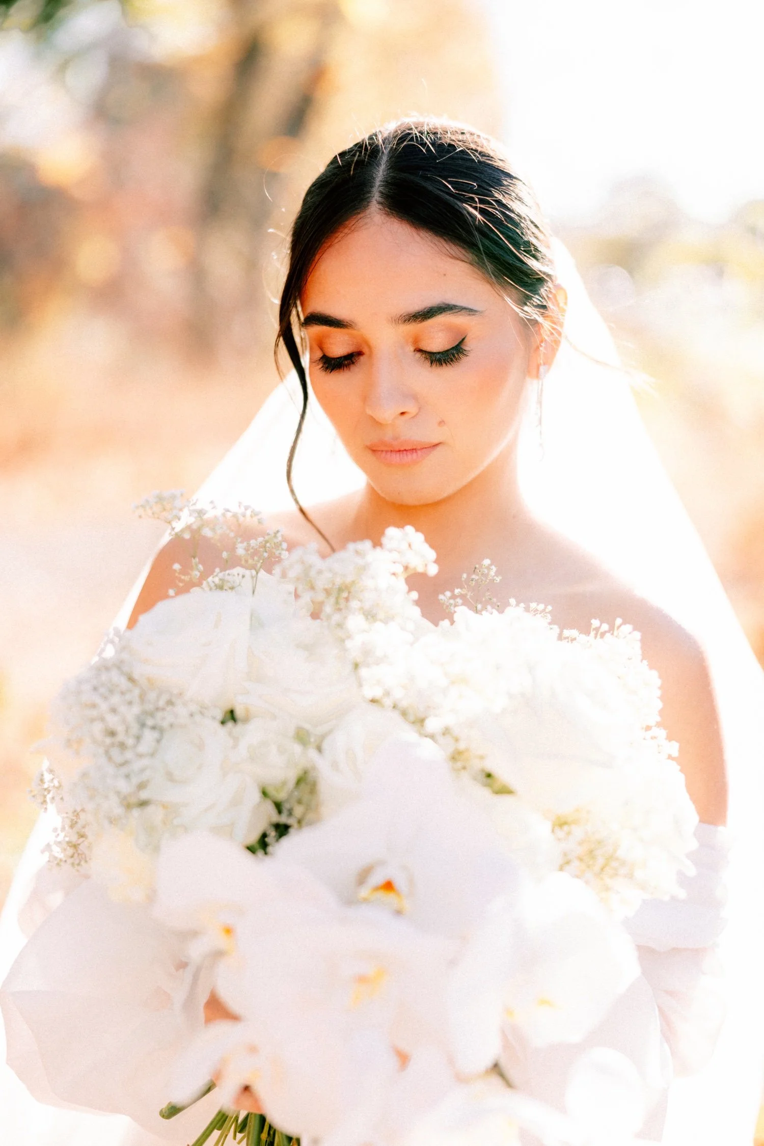 editorial photograph of bride looking at her white mira mira bouquet on her wedding day at the roundhouse